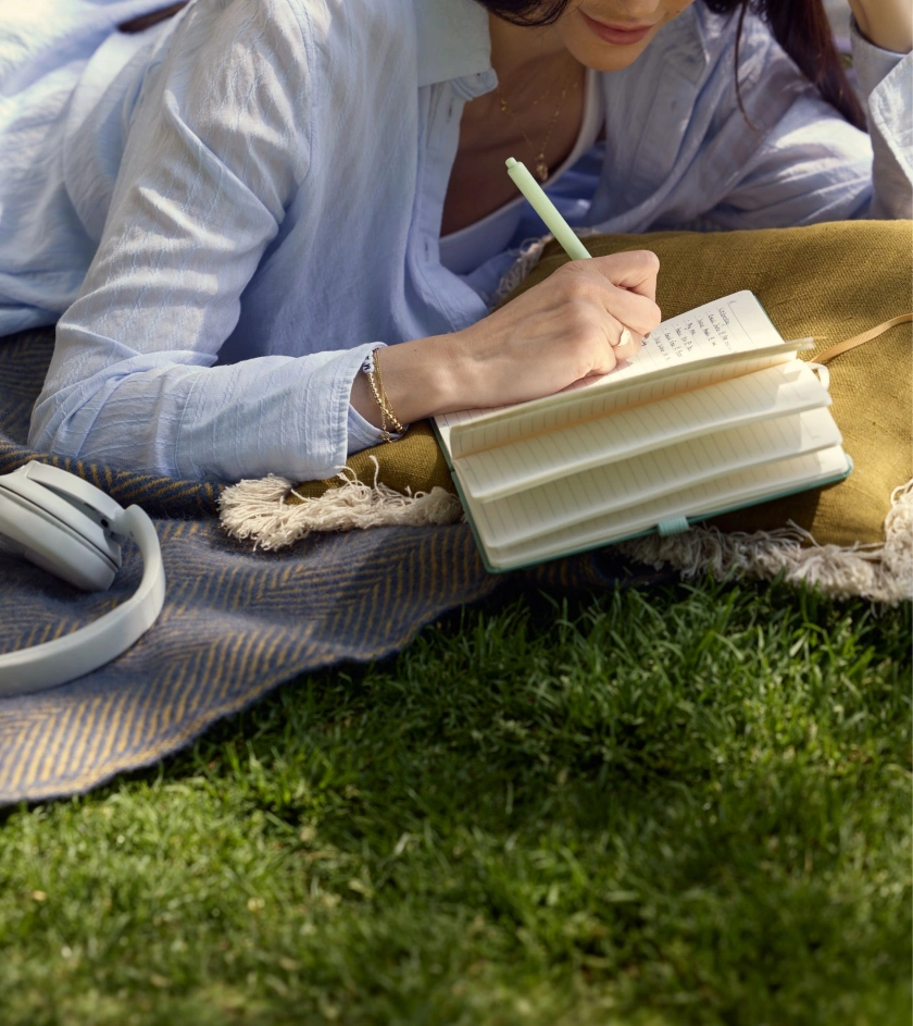 girl writing in a book in the park